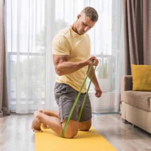 man doing fitness home using elastic band